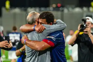 Asher Nolting and Coach Holman embrace after a hard-fought win (Photo courtesy of Zach Rilley).
